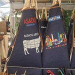 arafed aprons with various designs on them are hanging on a rack