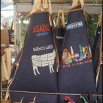arafed aprons with various designs on them are hanging on a rack