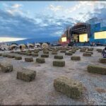 arafed hay bales are arranged in a field with a stage in the background