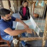 araffes are weaving a piece of fabric on a loom