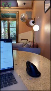 laptop on a table with a mouse and a lamp in a room
