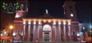 nighttime view of a church with a fountain and clock tower