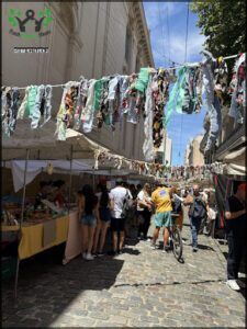 people are shopping at a market in a city street