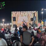 people are sitting at tables in a crowded outdoor area