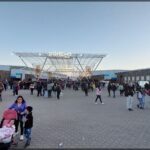people walking around a plaza with a large crowd of people