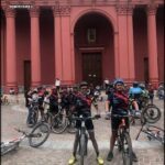 several people on bicycles are standing in front of a building