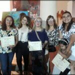 several women are posing for a picture with their certificates