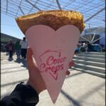 someone holding a piece of pizza in their hand with a heart on it