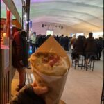 someone holding a wrap that has a sandwich in it