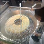 someone is cooking a large pan of food with a spatula