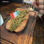 someone is cutting a piece of bread with a flag on it