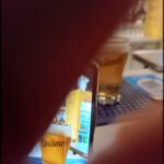 someone is using a cell phone to take a picture of a beer