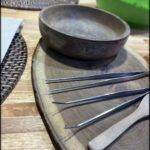 there are a lot of utensils on a wooden plate