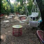 there are many chairs and tables in the middle of a forest