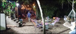 there are many chairs and tables in the yard at night