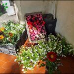 there are many different flowers in baskets on the floor