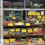 there are many fruits and vegetables on display outside of a store