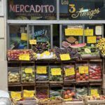 there are many fruits and vegetables on display outside of a store