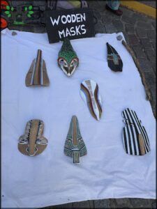 there are many masks on a table with a sign on it