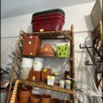 there are many pots and containers on a shelf in a room