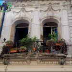 there are many potted plants on the balcony of a building