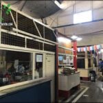 there are people standing in a building with a large machine