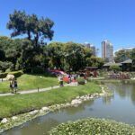 there are people walking along the path near a pond