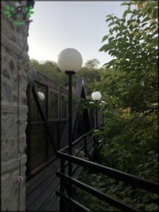 there are three white lamps on a stone wall near a building