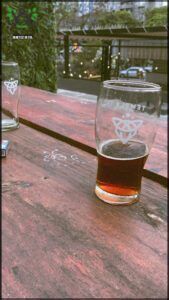 there are two glasses of beer on a table with a book