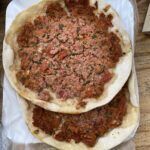 there are two pizzas sitting on a table with a knife and a knife