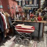 there is a baby carriage in a store with clothes on display