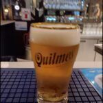there is a glass of beer sitting on a table in a restaurant