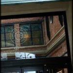 there is a green building with a green door and a clock on it