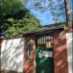there is a green door and a white wall in a courtyard