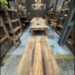 there is a long table with a wooden top in a room