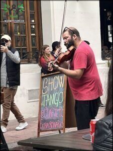 there is a man playing a violin on the street