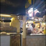 there is a man standing in a kitchen preparing food