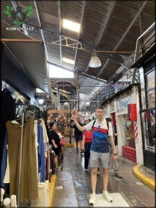 there is a man standing in a store with a lot of clothes