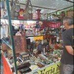 there is a man standing in front of a display of items