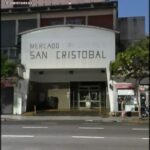 there is a man walking down the street in front of a building