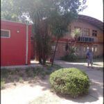 there is a man walking in front of a building with a red door