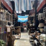 there is a narrow alley with a lot of items on display