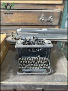 there is a old typewriter sitting on a table with a box