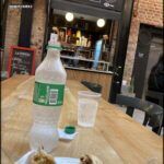 there is a plate of food on a table with a bottle of water