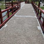 there is a red bridge that has a red railing over it