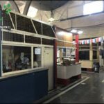 there is a small store with a large window and a lot of people