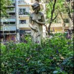 there is a statue of a woman in a garden with flowers