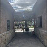 there is a stone walkway with a bench and a table in it