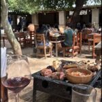 there is a table with a grill and a glass of wine on it