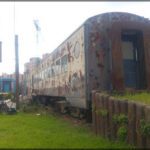 there is a train that is sitting on the tracks in the grass
